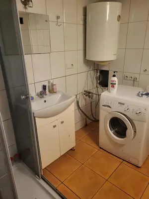 a bathroom with a washing machine and a sink at Grzegorzecka Room nr 2 in Kraków
