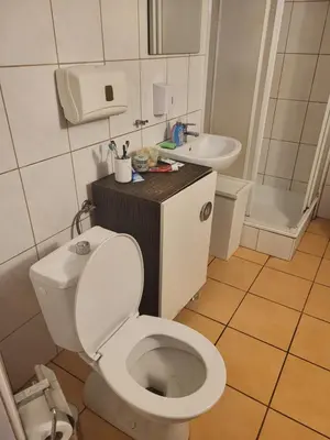a bathroom with a white toilet and a sink at Grzegorzecka Room nr 2 in Kraków