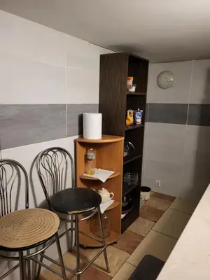 a room with two chairs and a table and a shelf at Grzegorzecka Room nr 2 in Kraków