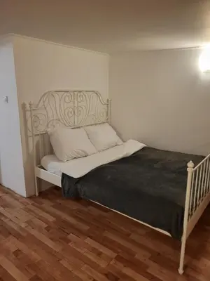a bed in a small room with a wooden floor at Grzegorzecka Room nr 2 in Kraków