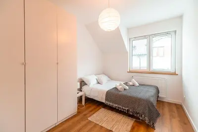 a bedroom with a bed and a window at Modlnica Wierzbowa Cosy Apartment by BookingHost in Kraków