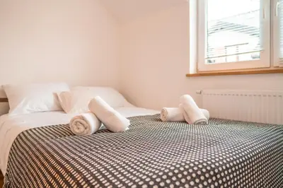 a bedroom with a bed with towels on it at Modlnica Wierzbowa Cosy Apartment by BookingHost in Kraków