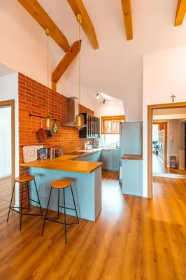 a kitchen with a blue island and wooden floors at Modlnica Wierzbowa Cosy Apartment by BookingHost in Kraków