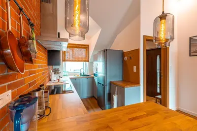 a kitchen with blue appliances and a brick wall at Modlnica Wierzbowa Cosy Apartment by BookingHost in Kraków