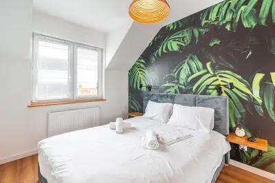 a bedroom with a large white bed with a mural at Modlnica Wierzbowa Cosy Apartment by BookingHost in Kraków