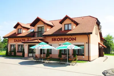 two umbrellas and chairs in front of a store at Zajazd Skorpion B&B in Oświęcim