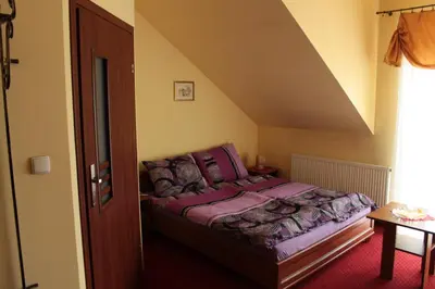 a small bedroom with a bed with purple sheets at Zajazd Skorpion B&B in Oświęcim