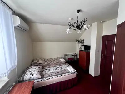 a bedroom with two beds and a chandelier at Zajazd Skorpion B&B in Oświęcim