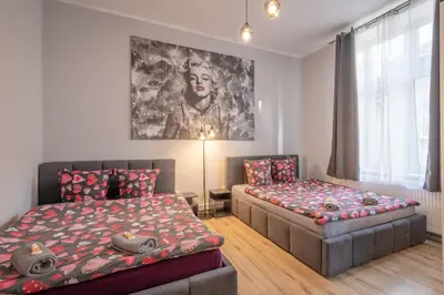 a bedroom with a bed and a desk in it at 70s Hostel in Kraków