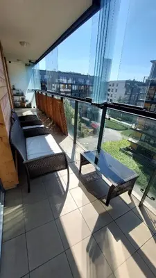 a balcony with two chairs and a large window at Masarska Family Apartment free Parking in Kraków