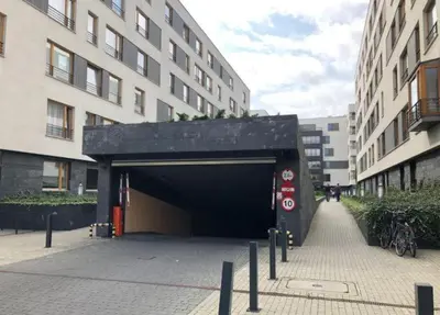 a black garage in a city with buildings at Masarska Family Apartment free Parking in Kraków
