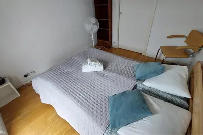 a small bedroom with a bed and a fan at Masarska Family Apartment free Parking in Kraków