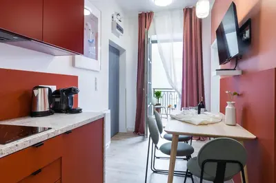 a kitchen with a table and chairs in a room at Zabłocie Residence in Kraków