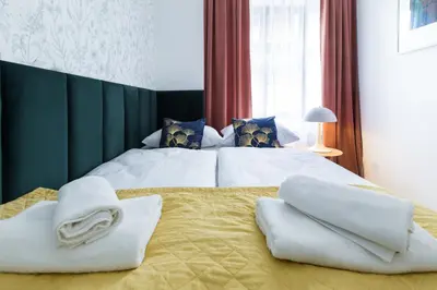 a bedroom with two beds with towels on the bed at Zabłocie Residence in Kraków