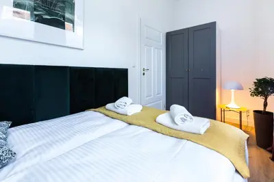 a bedroom with a large bed with towels on it at Zabłocie Residence in Kraków