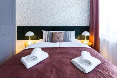 a bedroom with a large bed with towels on it at Zabłocie Residence in Kraków