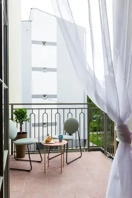 a balcony with a table and chairs and a window at Zabłocie Residence in Kraków