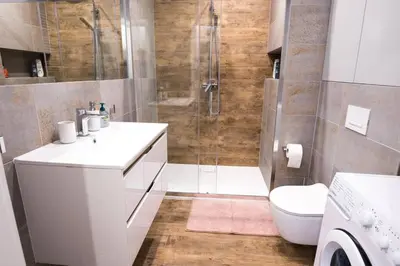 a bathroom with a shower and a sink and a toilet at Nowoczesny Apartament Dąbska Arena / Parking in Kraków