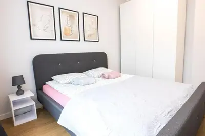 a bedroom with a bed with two pillows on it at Nowoczesny Apartament Dąbska Arena / Parking in Kraków