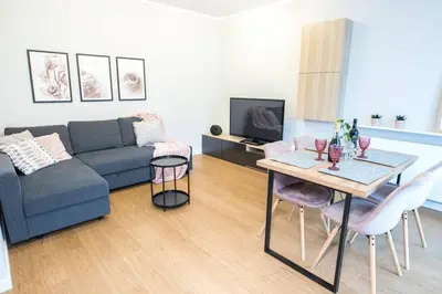 a living room with a couch and a table at Nowoczesny Apartament Dąbska Arena / Parking in Kraków