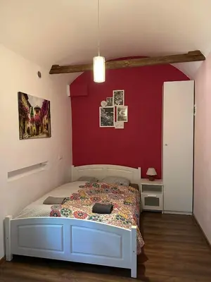 a bedroom with a bed and a red wall at City Centre Apartment Wielopole in Kraków