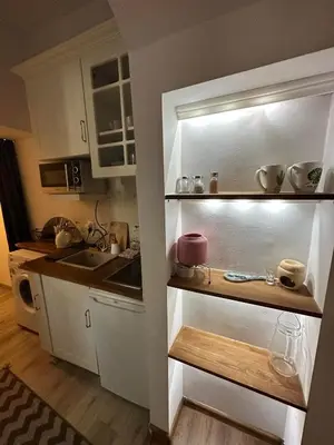 a kitchen with white cabinets and a counter top at City Centre Apartment Wielopole in Kraków