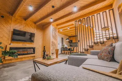 a living room with a couch and a fireplace at Słone Wzgórze in Rabka