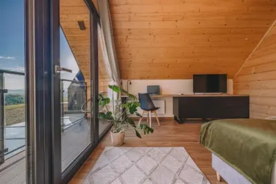 a room with a bed and a desk and a window at Słone Wzgórze in Rabka