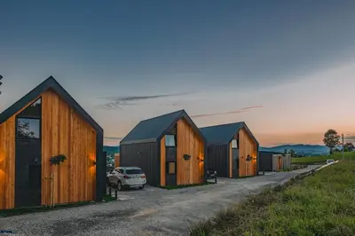 a row of wooden homes with a car parked in front at Słone Wzgórze in Rabka