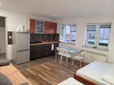 a kitchen with a refrigerator and a table and chairs at Apartamenty Kącik 8 in Kraków