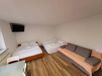 a room with two beds and a flat screen tv at Apartamenty Kącik 8 in Kraków