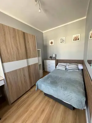a bedroom with a large bed and a wooden cabinet at Walenty Kraków in Kraków