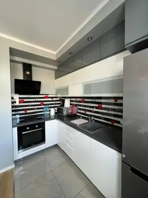 a large kitchen with white cabinets and a sink at Walenty Kraków in Kraków