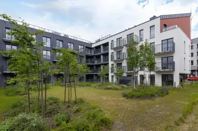 an apartment building with trees in the yard at Modern Studio & Terrace Kiełkowskiego by Noclegi Renters in Kraków