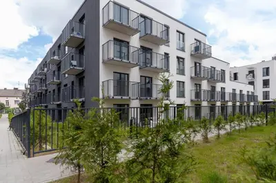 an apartment building with black balconies and trees at Modern Studio & Terrace Kiełkowskiego by Noclegi Renters in Kraków