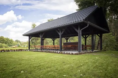 a picnic shelter with benches in a park at Dworek nad Rozlewiskiem in Olkusz
