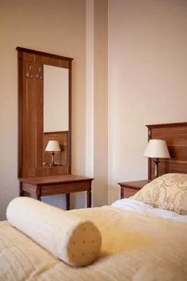 a hotel room with a bed and a mirror at Dworek nad Rozlewiskiem in Olkusz