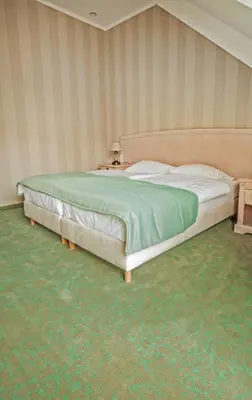 a bedroom with a large bed and a table at Dworek nad Rozlewiskiem in Olkusz