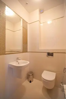 a white bathroom with a toilet and a sink at Dworek nad Rozlewiskiem in Olkusz