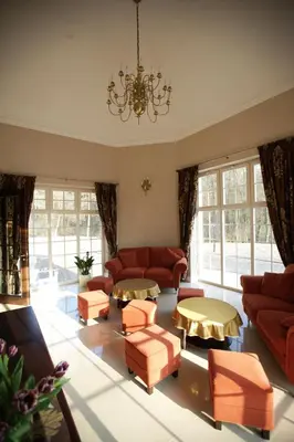 a living room with red furniture and a chandelier at Dworek nad Rozlewiskiem in Olkusz
