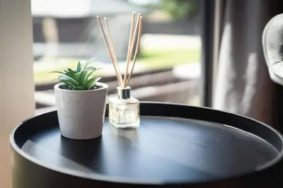 a table with a bottle of perfume and a plant on it at VILLAGE RESORT Sauna & Jacuzzi & Netflix in Tworkowa
