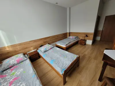a room with three beds and a table at Złota Róża in Sędziszów