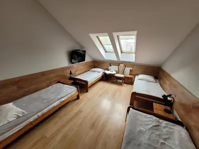 a attic room with three beds and a tv at Złota Róża in Sędziszów