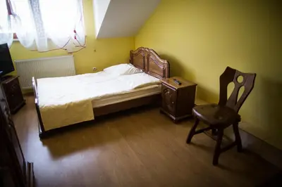 a small bedroom with a bed and a chair at Złota Róża in Sędziszów