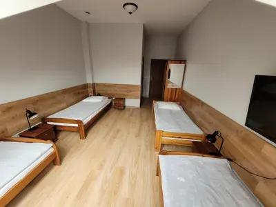 a room with three beds and a flat screen tv at Złota Róża in Sędziszów