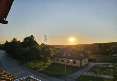 a house with the sunset in the background at Złota Róża in Sędziszów