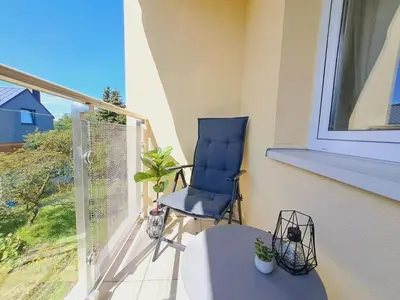 a blue chair sitting on a balcony with a window at Limanowa Sunriser Apartment in Limanowa