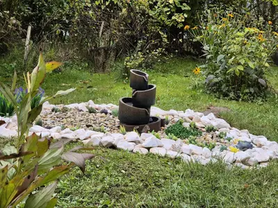 a rock garden with a sculpture in the grass at Limanowa Sunriser Apartment in Limanowa
