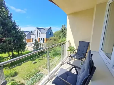 a balcony with two chairs and a view of a house at Limanowa Sunriser Apartment in Limanowa