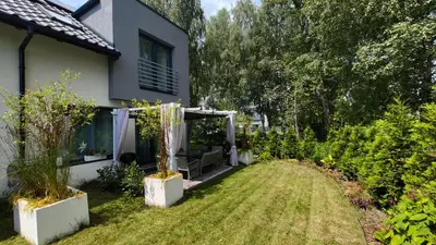 a garden with a pergola in front of a house at Domek Zielone Marzenie in Chrzanów